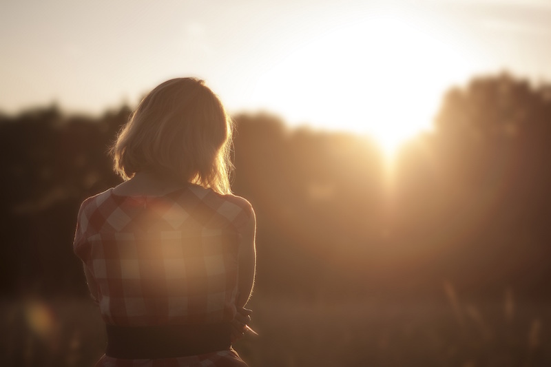 Girl thinking, facing Sunset